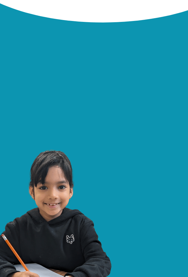 Photo of a LiftED program participant writing on a piece of paper and smiling at the camera